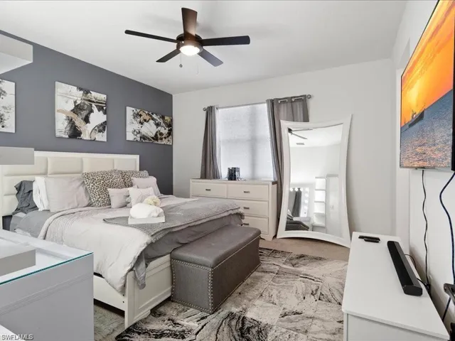 Carpeted bedroom with a ceiling fan