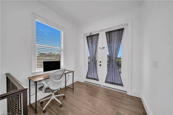 Office space with wood finish floors, plenty of natural light, and french doors