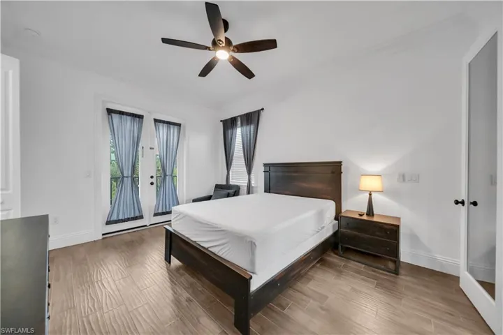 Bedroom with crown molding, wood tiled floors, access to outside, and a ceiling fan