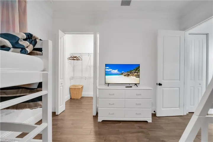 Bedroom featuring dark wood-type flooring and baseboards