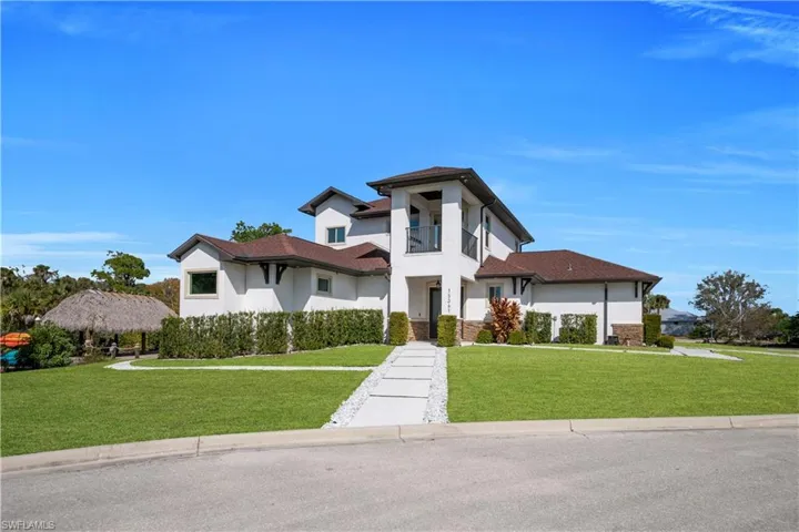 View of front of home with a front lawn, stucco siding, and a balcony