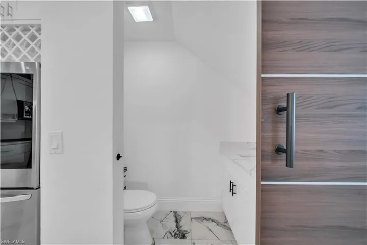 Bathroom with vanity and light marble finish flooring