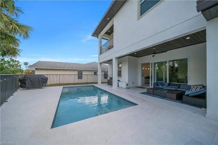 View of pool with an outdoor living space, a balcony, patio surround, and area for grilling