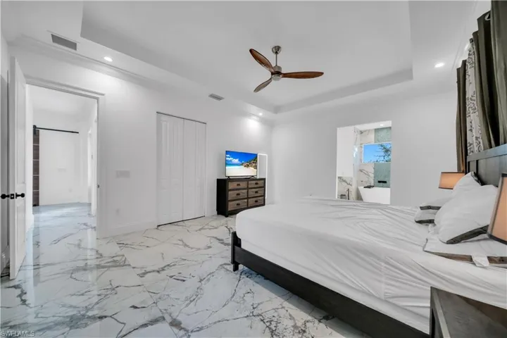 Bedroom featuring recessed lighting, a ceiling fan, a closet, ornamental molding, and a raised ceiling