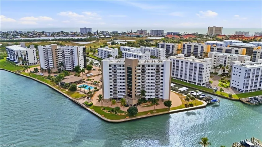 View of Harbour Pointe with pool to the left and the canal with Boat Docks to the right  - Virtually Edited Image