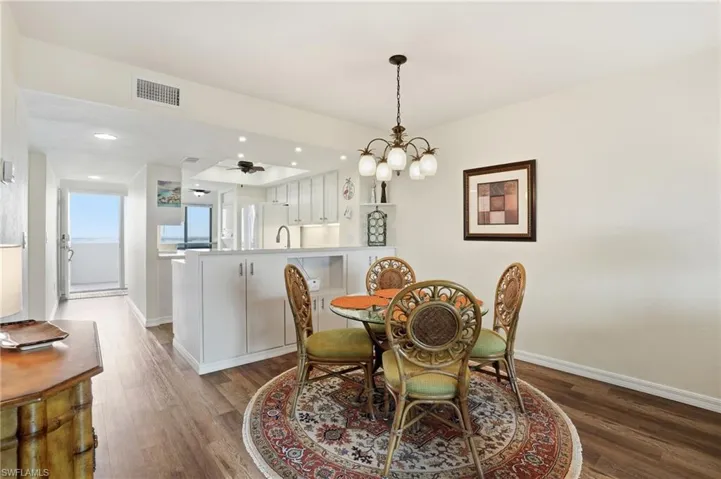 Bright and spacious diining space with a chandelier, recessed lighting - Virtually Edited Image