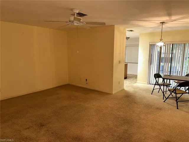 Carpeted empty room with ceiling fan