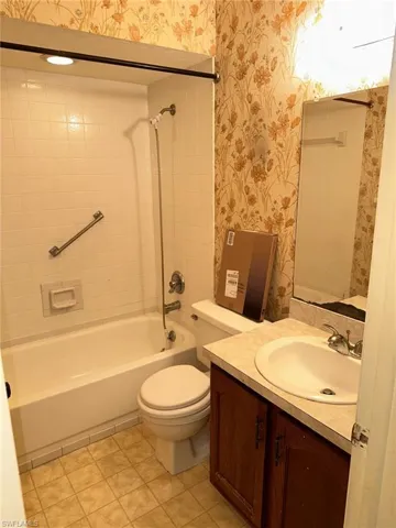 Full bathroom with tiled shower / bath, tile flooring, toilet, and vanity