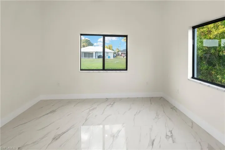 Unfurnished room with baseboards and light marble finish floors