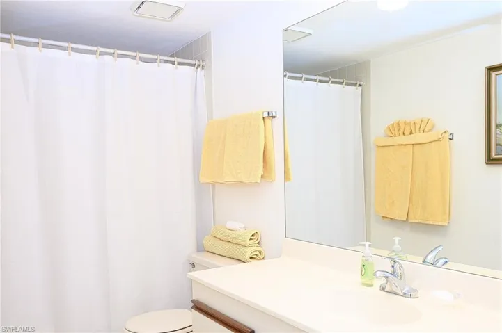 Bathroom featuring vanity, toilet, and a shower with curtain