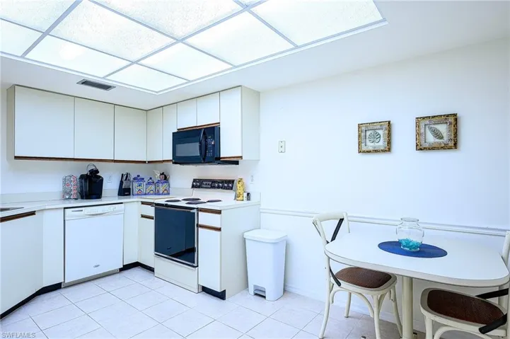 Kitchen featuring white appliances and white cabinets