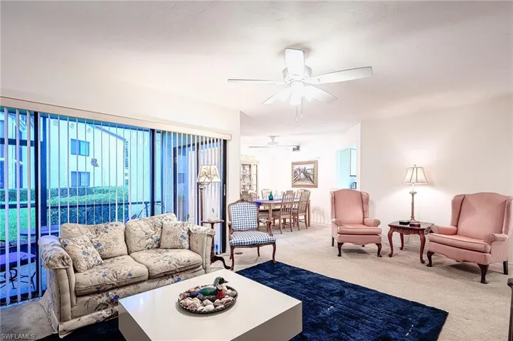 Carpeted living room with ceiling fan