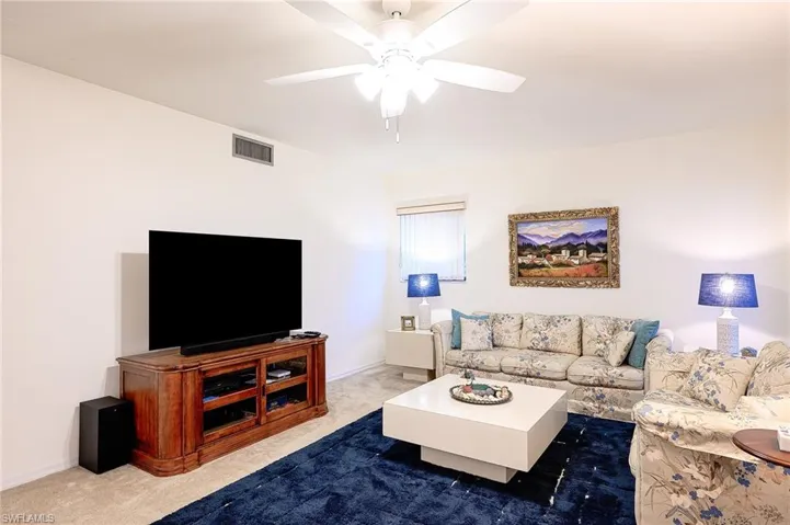Living room featuring carpet and ceiling fan