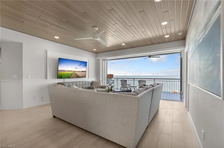 Living room with ceiling fan, light wood-style floors, wooden ceiling, wainscoting, and recessed lighting