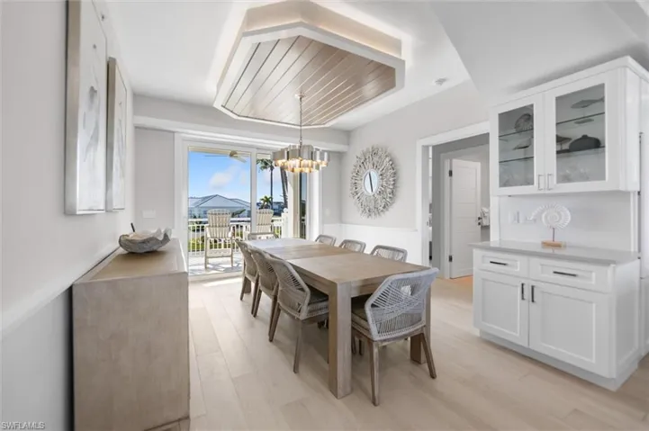 Dining space featuring a wainscoted wall, light wood-type flooring, and a chandelier
