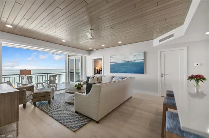 Living area with a ceiling fan, a water view, recessed lighting, and wood ceiling