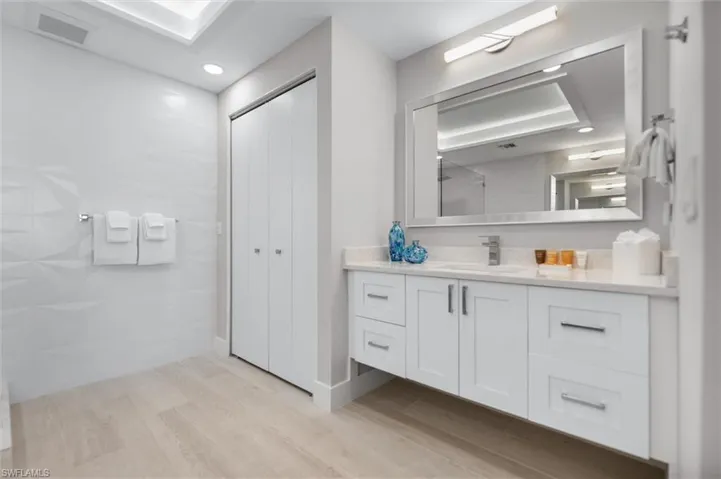 Full bathroom featuring vanity, light wood-type flooring, a shower, a closet, and recessed lighting