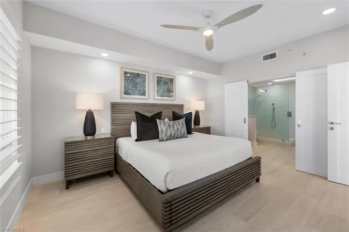 Bedroom with light wood-style flooring, ensuite bathroom, a ceiling fan, and recessed lighting
