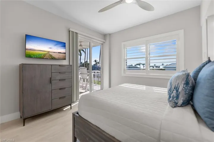 Bedroom featuring access to exterior, light wood-type flooring, and ceiling fan