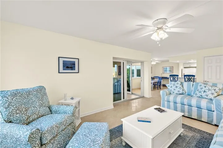 Living area with a ceiling fan and tile patterned flooring
