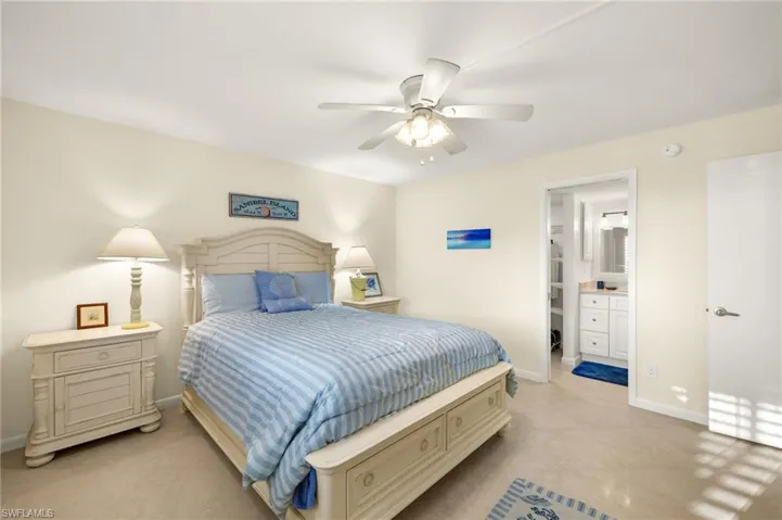 Bedroom with connected bathroom, a ceiling fan, and light tile patterned floors
