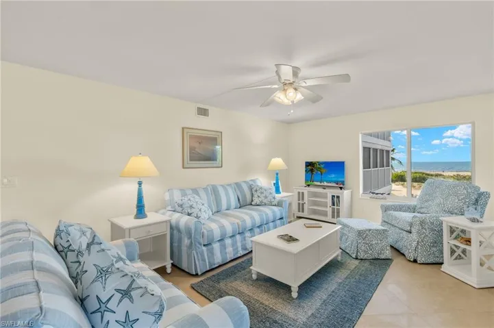 Living area with ceiling fan and tile patterned floors