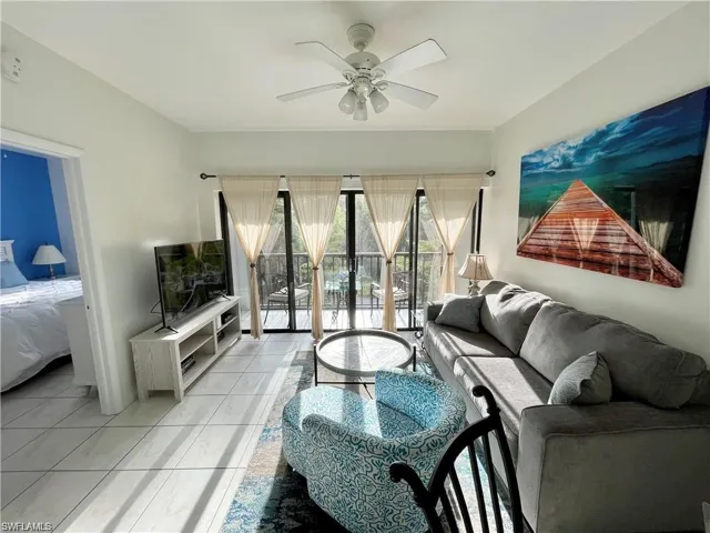 Living room with light tile patterned flooring and ceiling fan