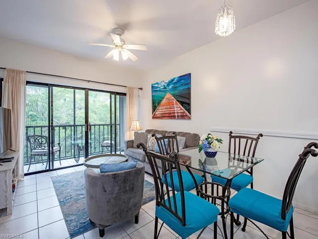 Tiled dining room with ceiling fan with notable chandelier