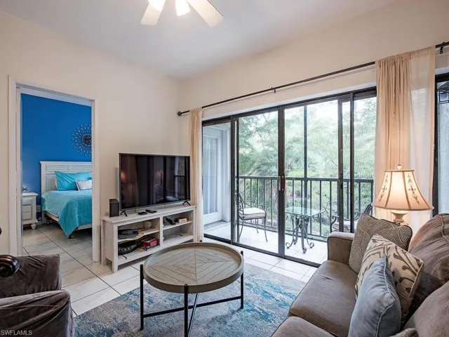 Living room with light tile patterned floors and ceiling fan