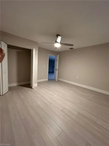 Unfurnished bedroom featuring a closet, light hardwood / wood-style flooring, and ceiling fan