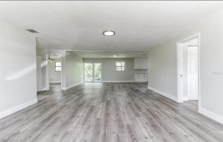 Unfurnished living room with light wood-type flooring and ceiling fan