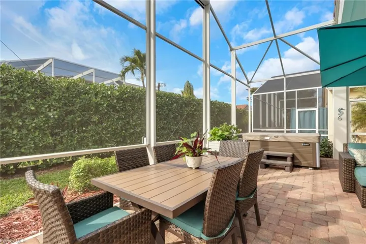 Sunroom / solarium featuring a jacuzzi, a patio, outdoor dining space, and healthy amount of natural light