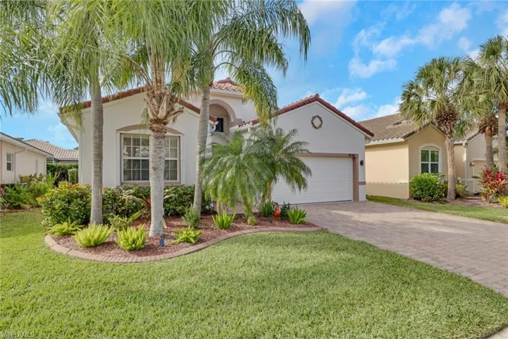 Mediterranean / spanish house featuring a tile roof, a front lawn, decorative driveway, stucco siding, and a garage