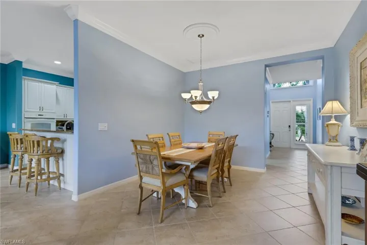 Dining space featuring ornamental molding, light tile patterned floors, and a chandelier