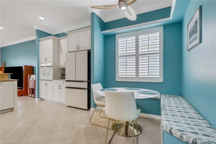 Kitchen with white appliances, white cabinets, crown molding, a ceiling fan, and recessed lighting