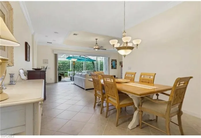 Dining space featuring ornamental molding, a sunroom, ceiling fan, and light tile patterned floors
