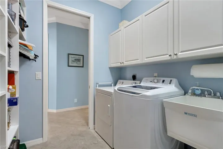 Laundry room featuring cabinet space, independent washer and dryer, and crown molding