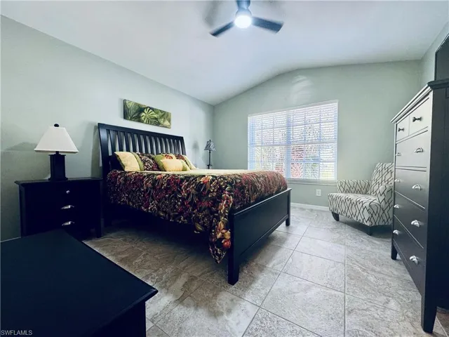 Bedroom featuring baseboards, a ceiling fan, and lofted ceiling