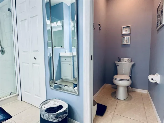 Full bath featuring vanity, baseboards, tile patterned flooring, a closet, and toilet