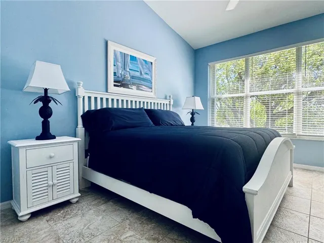 Bedroom with baseboards, ceiling fan, and vaulted ceiling