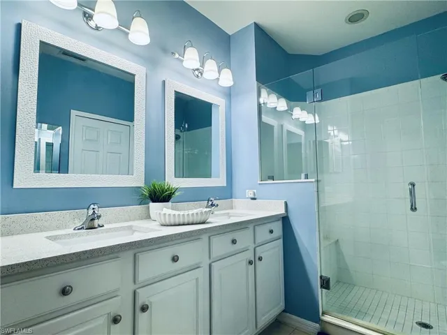 Full bathroom with a sink, a stall shower, and double vanity