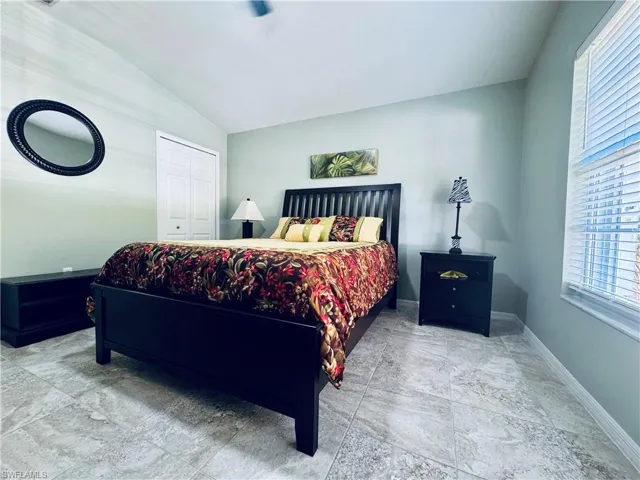 Bedroom with baseboards and lofted ceiling