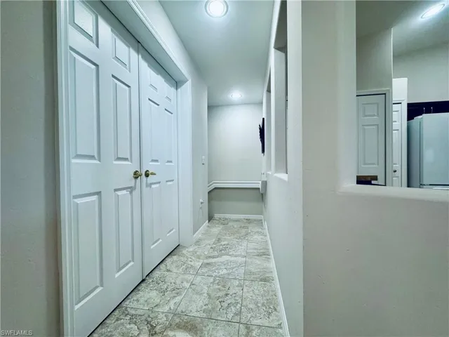 Hallway featuring recessed lighting and baseboards