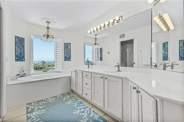 Bathroom with tile patterned flooring, vanity, and a bath