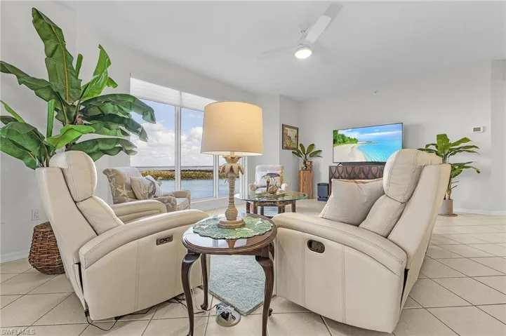 Living room featuring light tile patterned floors and ceiling fan