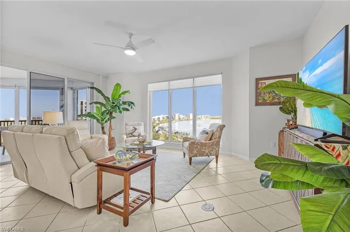 Living room featuring light tile patterned floors and ceiling fan