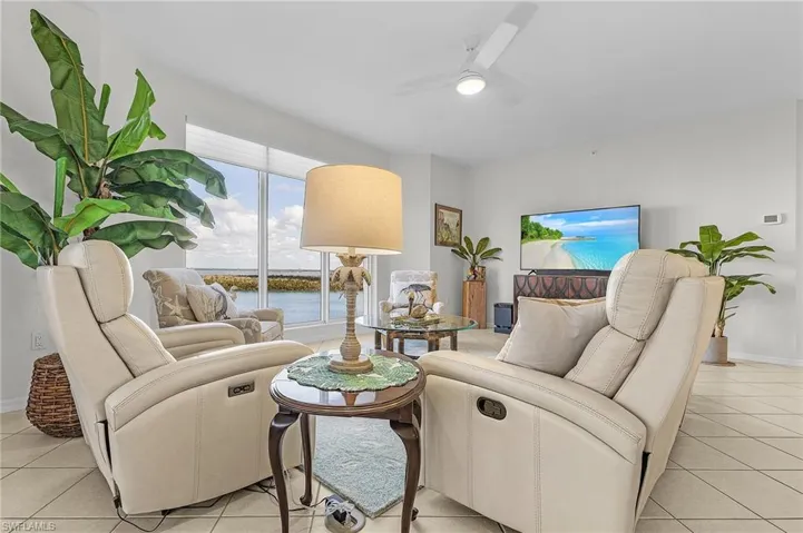 Living room with ceiling fan and light tile patterned floors