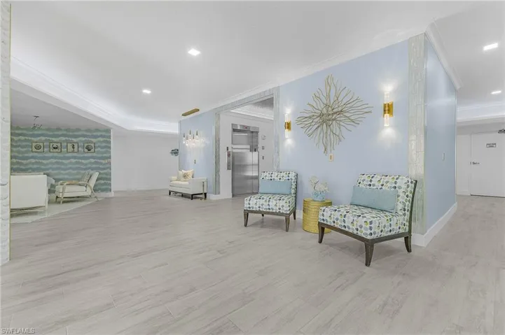 Living area with crown molding, elevator, and light hardwood / wood-style flooring