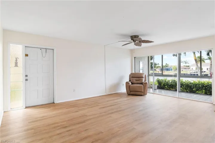 Unfurnished room with light wood-type flooring, a water view, and ceiling fan