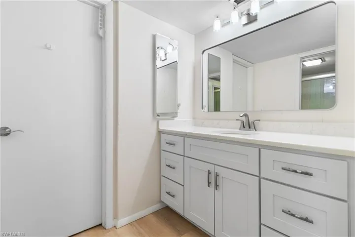 Bathroom featuring hardwood / wood-style floors, vanity, and walk in shower
